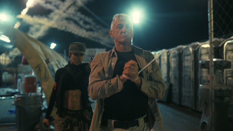 Perfidia walking a captured Lockjaw through a detention center at gunpoint in One Battle After Another