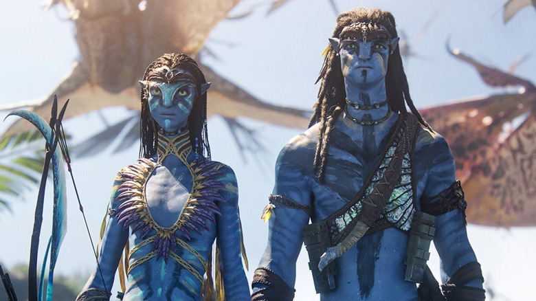 A close-up of Zoe Salda&ntilde;a as Neytiri and Sam Worthington geared up for war in Avatar: Fire & Ash