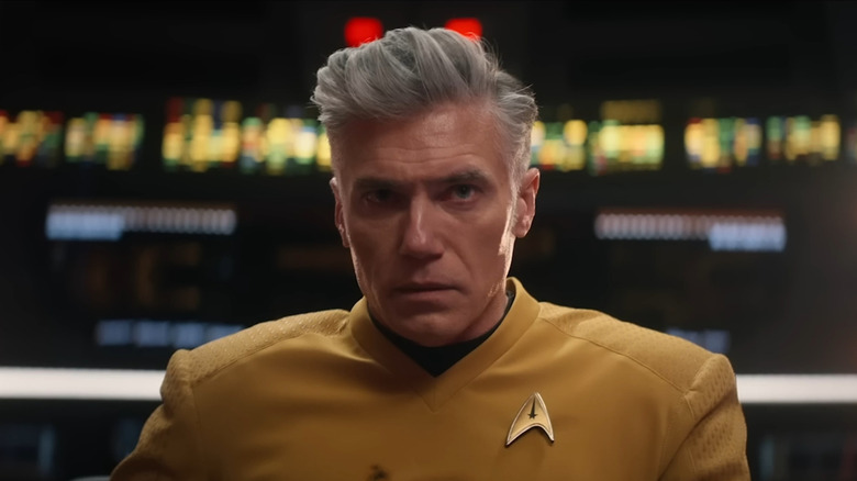 Anson Mount as Christopher Pike sitting in a captain's chair in front of a row of computer displays in Star Trek: Strange New Worlds