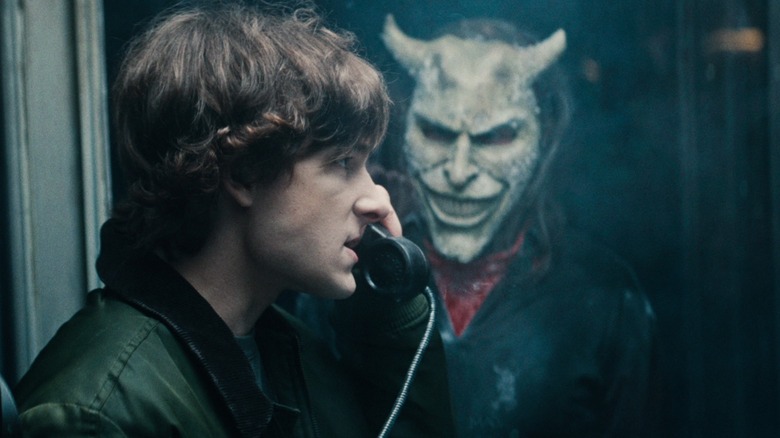 The Grabber looking at Finny while he's on the phone in Black Phone 2