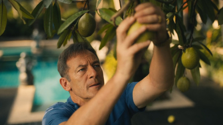 Jason Isaacs as Timothy Ratliff grabbing a piece of poisonous fruit on The White Lotus