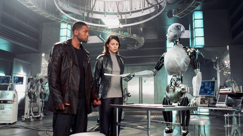 డిటెక్టివ్ డెల్ స్పూనర్ మరియు తోటి పోలీసు I, రోబోట్‌లోని రోబోట్ నుండి కాగితాన్ని పొందుతున్నారు