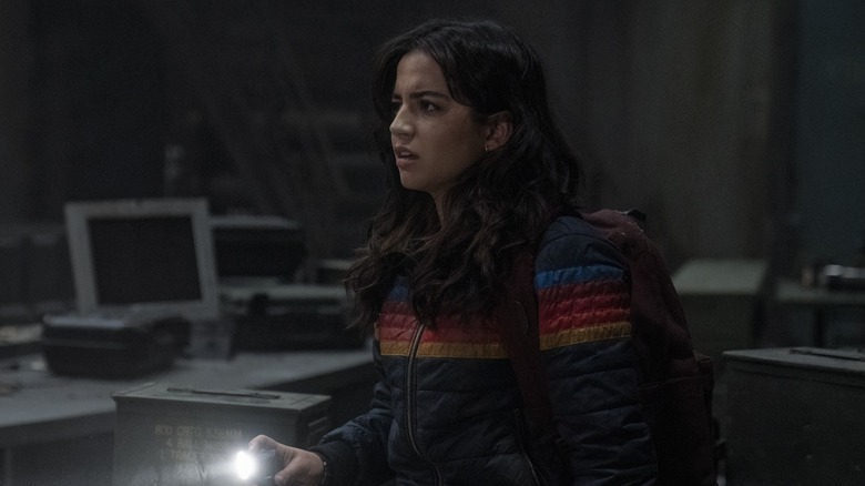 Dina in her rainbow jacket holding a flashlight in The Last of Us