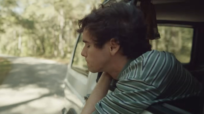 A character leaning out a car window in It Ends