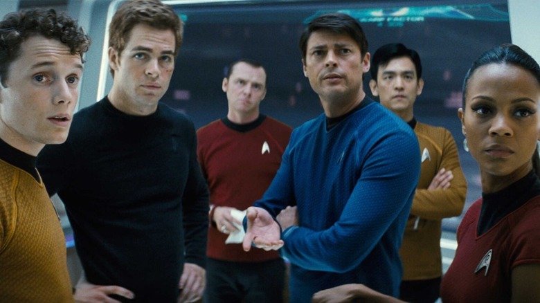 Anton Yelchin as Pavel Chekov, Chris Pine as James Kirk, Simon Pegg as Montgomery Scott, Karl Urban as Leonard McCoy, John Cho as Hikaru Sulu, and Zoe Saldaña as Nyota Uhura standing together in Star Trek (2009)