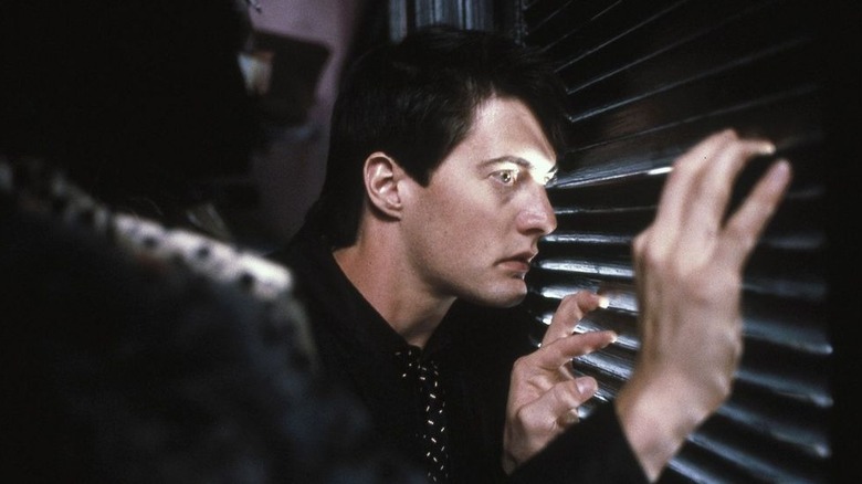 Jeffrey peeking through some blinds in Blue Velvet
