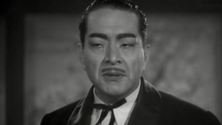 A closeup of Dr. Daka, played by a white actor in racist Japanese makeup.