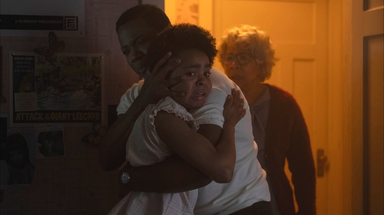 A frightened Ronnie hugs her father for comfort in It: Welcome to Derry