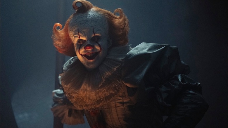 Pennywise grins at some unfortunate soul offscreen in It: Welcome to Derry