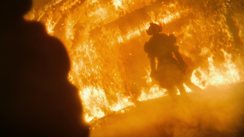 Bill Skarsgård as Pennywise engulfed in flames in It: Welcome to Derry