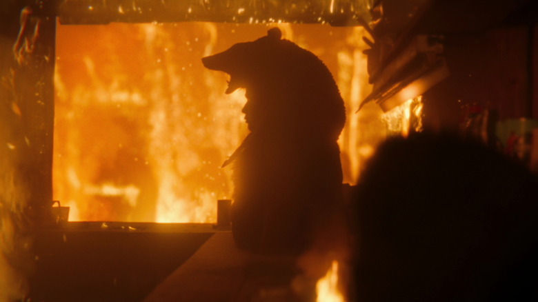 Morningstar Angeline as Seski wearing an animal pellet in the midst of a burning building in It: Welcome to Derry