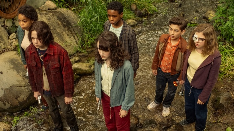 Ronnie, Matty, Lilly, Will, Rich, and Marge standing in the woods in It: Welcome to Derry