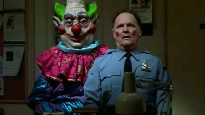 John Vernon's Curtis Mooney sits on a Klown's lap in Killer Klowns from Outer Space