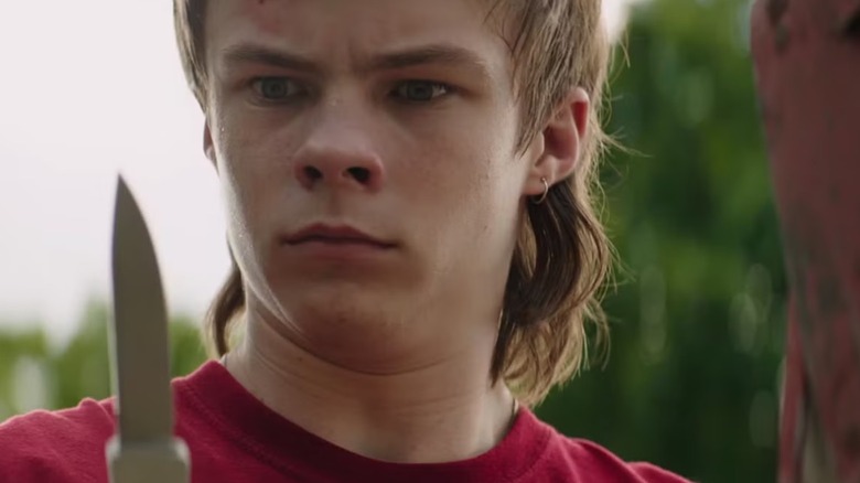 Henry Bowers (Nicholas Hamilton) holding a knife in It: Chapter One
