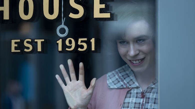 Scary person looking through glass window in IT: Welcome to Derry