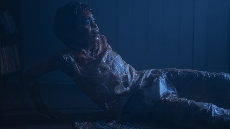 Amanda Christine's Ronnie Grogan looks scared as she lays on the floor of her room in It: Welcome to Derry