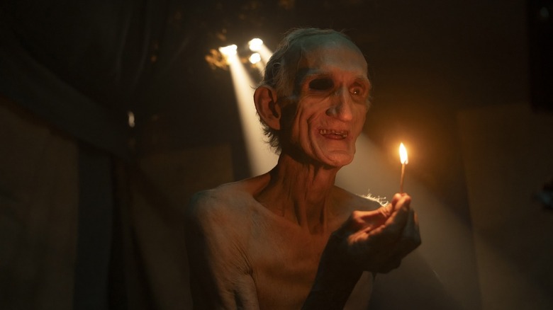 Peter Schoelier's skeleton man holds up a lit match in It: Welcome to Derry