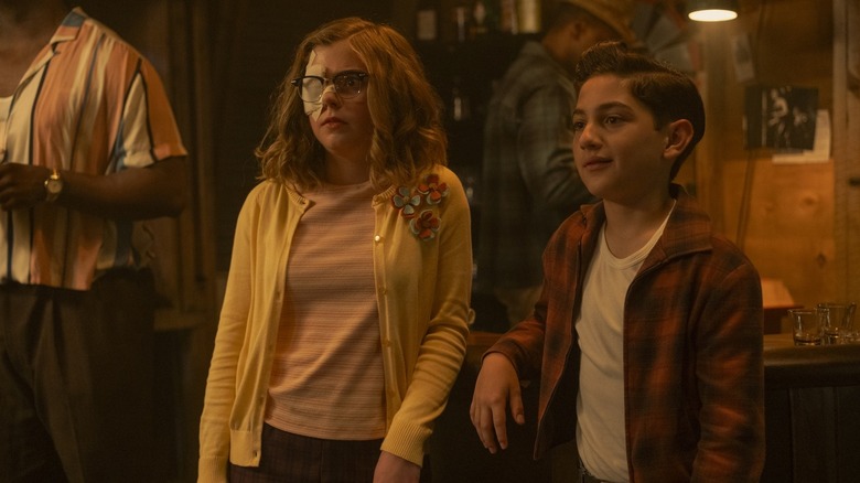 Matilda Lawler's Marge Truman stands next to Arian S. Cartaya's Rich Santos at the Black Spot in It Welcome to Derry.jpg