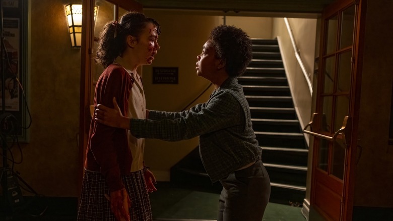 Lilly, with blood on her face, looks at Ronnie in It: Welcome to Derry