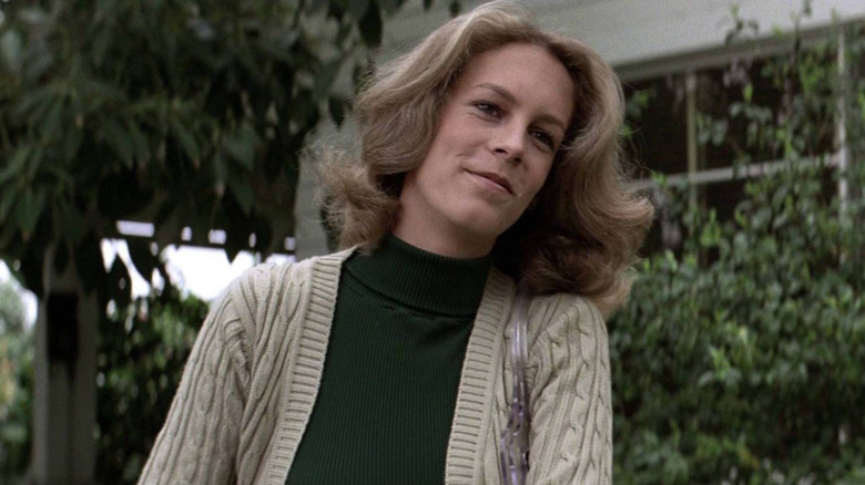Laurie Strode smiling in a green sweater and cardigan in Halloween (1978)