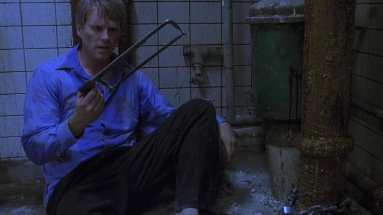 Lawrence holds a saw in a chainsaw