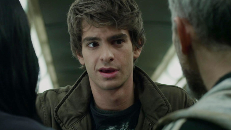 Peter Parker facing two people on a subway train in The Amazing Spider-Man