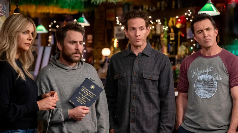 Dee, Charlie, Dennis, and Mac looking wary at their bar in It's Always Sunny in Philadelphia