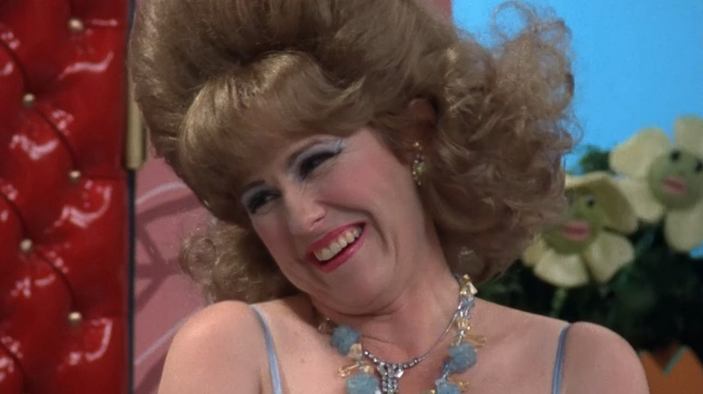 Lynne Marie Stewart as Miss Yvonne on Pee-Wee's Playhouse, smiling with flower puppets behind her
