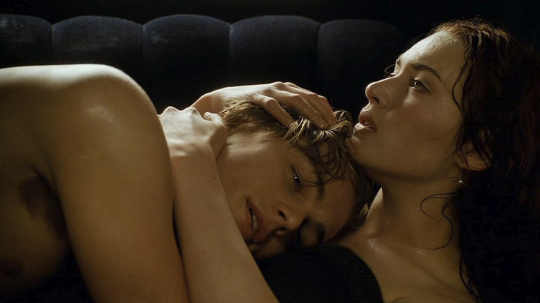 Rose holding a shirtless Jack tightly to her chest in the backseat of the car in Titanic