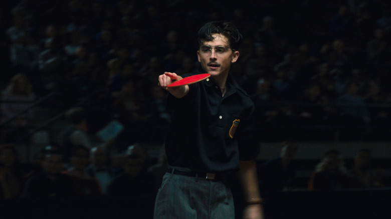 Marty pointing at his opponent during a ping pong match in Marty Supreme