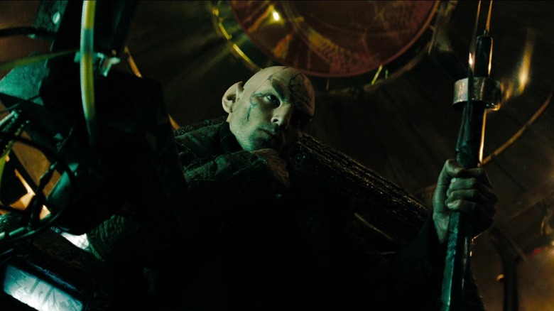 Nero holding a staff while sitting in his chair in Star Trek