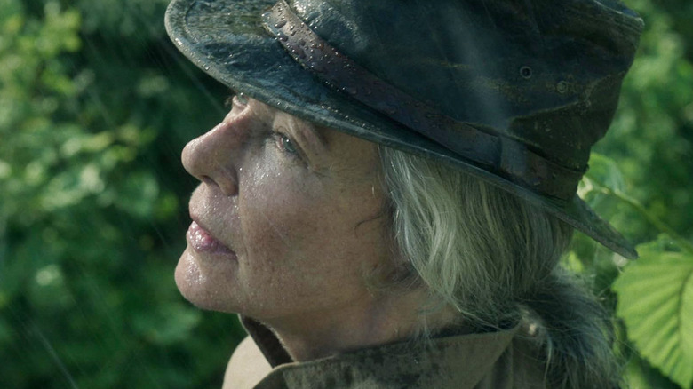 Allison Janney as Lou Adell wearing a hat while standing in the rain in Lou