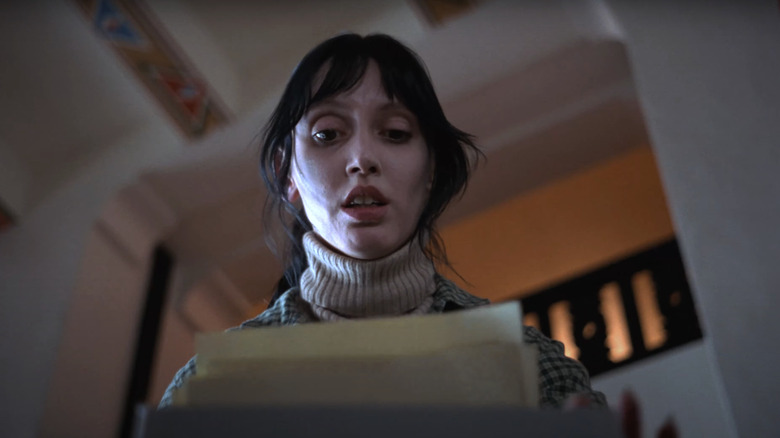 Shelley Duvall's Wendy Torrance looks down at her husband's writing sitting in the typewriter in The Shining