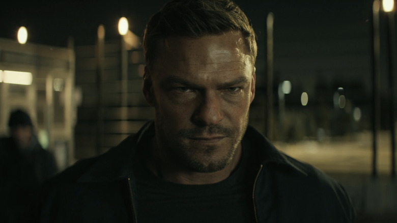 Alan Ritchson as Jack Reacher looking intensely focused in closeup in Reacher