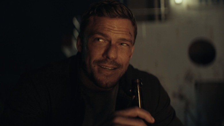 Alan Ritchson as Jack Reacher drinking a beer in Reacher