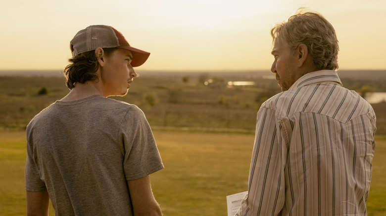 Jacob Lofland's Cooper Norris and Billy Bob Thornton's Tommy Norris are seen from behind as they stand side by side outside in Landman