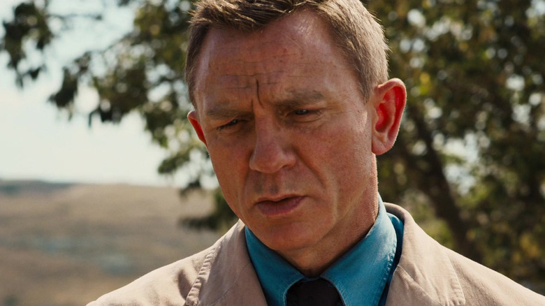 Daniel Craig as James Bond looking concerned in No Time to Die