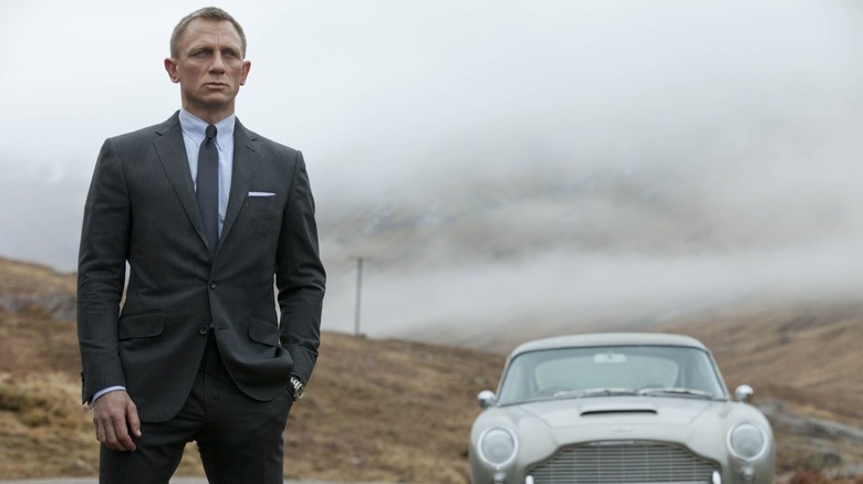 Daniel Craig standing in front of a car