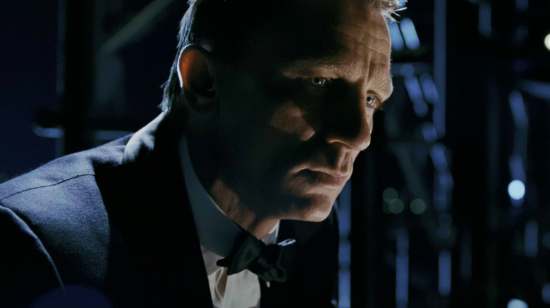Daniel Craig as James Bond looking despondent in the shadows