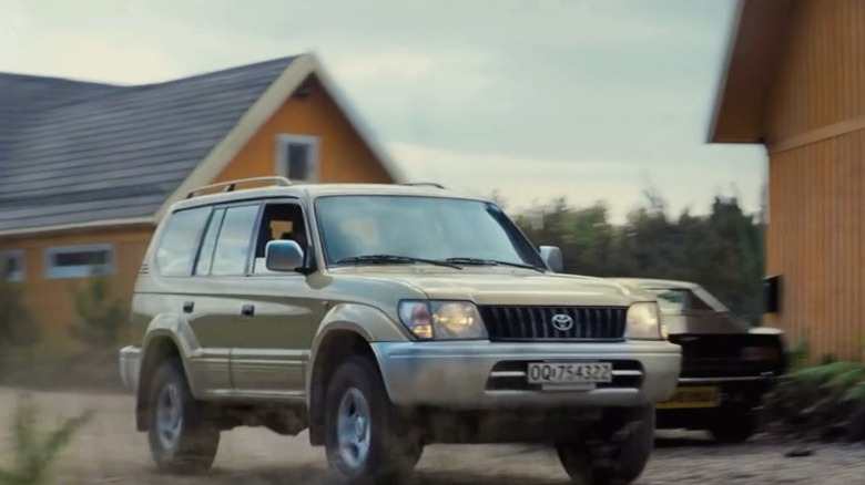 The 1998 Toyota Land Cruiser Prado passing by orange houses in No Time to Die