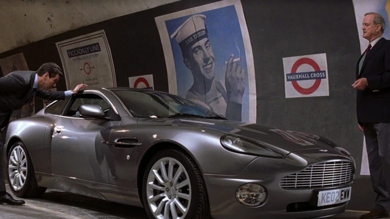 John Cleese as Q watching Pierce Brosnan as James Bond examine the 2002 Aston Martin V12 Vanquish in Die Another Day