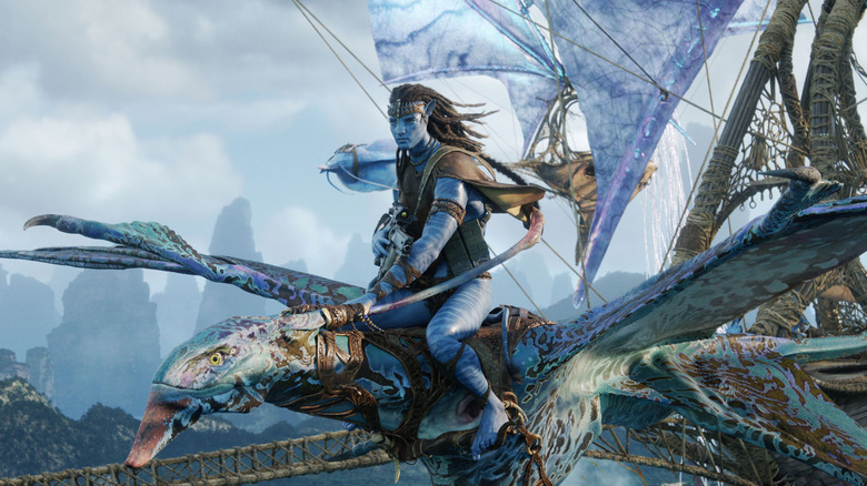 Jake Sully on the back of a dragon, with sailing ships behyind him, in Avatar: Fire and Ash