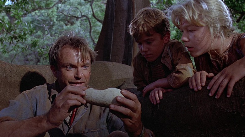 Sam Neill as Alan Grant holding a dinosaur egg shell with Tim and Lex in Jurassic Park