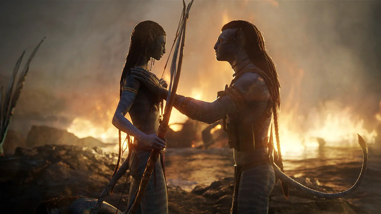 Neytiri dan Jake berdiri di depan kobaran api di Avatar: The Way of Water