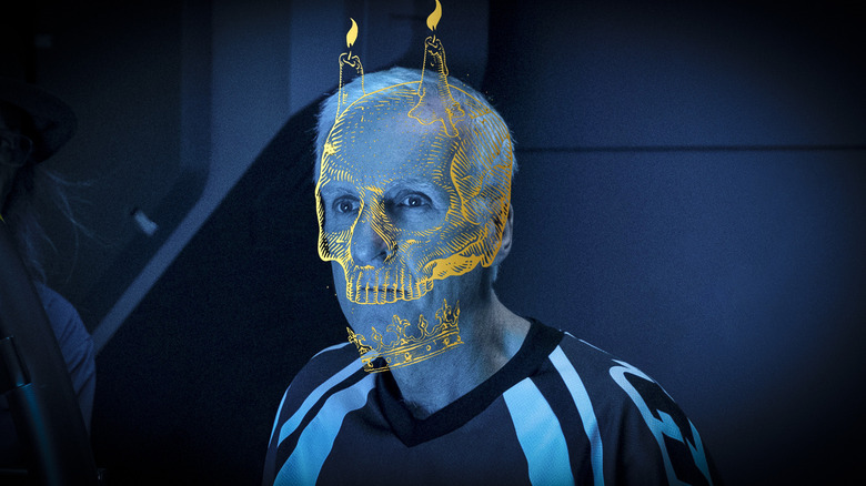 James Cameron bathed in blue light with a skull design over his face