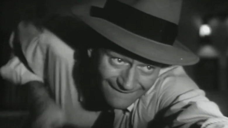 John Wayne's Steve Williams leans over a pool table in closeup in Trouble Along the Way