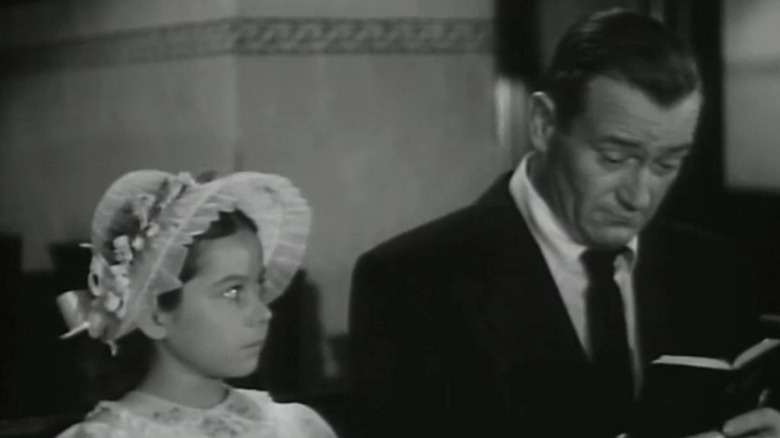 John Wayne's Steve Williams sits in church reading a bible alongside Sherry Jackson's Carole Williams in Trouble Along the Way
