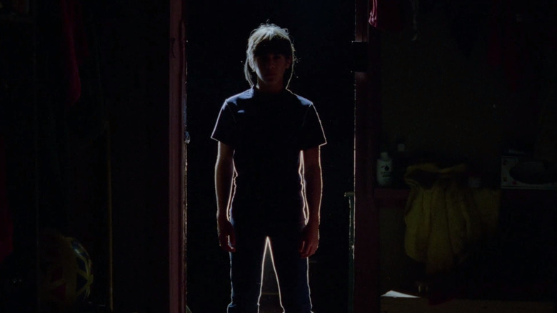 La silueta de un asesino se recorta contra una puerta en el campamento para dormir.