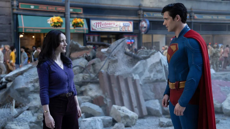Rachel Brosnahan as Lois Lane stands opposite David Corenswet as Superman in front of some rubble in Superman