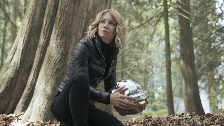 Jennifer Holland as Emilia Harcourt holding Peacemaker's helmet on Peacemaker